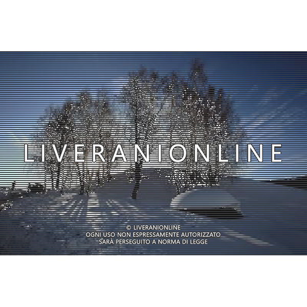 KANAS - MARCH 6: Tourists walk on a snow-covered hill in Hemu village at the Kanas nature reserve in Xinjiang Uygur Autonomous Region, China on Friday, March 6, 2009. Sharing borders with Kazakhstan, Russia and Mongolia, Kanas Nature Reserve boasts a beautiful natural ecosystem formed by lakes, rivers, glaciers, forests, and grasslands. Hemu Village, ranked by China National Geography as one of the six most beautiful villages in China, is one of the three residences of the Tuva Mongol in the country. The Tuva Mongol of Hemu Village lives in frame houses half-buried in the ground to resist the chillness of winter. They believe in Buddhism and have well preserved the traditional beliefs of their tribe.(Photo By Zhou You/ColorChinaPhoto) - AG. ALDO LIVERANI SAS ITALY ONLY