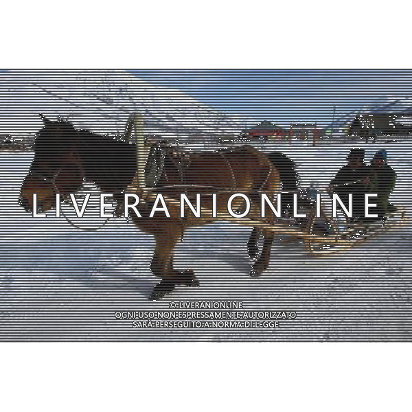 KANAS - MARCH 6: Herders ride a sleigh at the snow-covered Hemu village at the Kanas nature reserve in Xinjiang Uygur Autonomous Region, China on Friday, March 6, 2009. Sharing borders with Kazakhstan, Russia and Mongolia, Kanas Nature Reserve boasts a beautiful natural ecosystem formed by lakes, rivers, glaciers, forests, and grasslands. Hemu Village, ranked by China National Geography as one of the six most beautiful villages in China, is one of the three residences of the Tuva Mongol in the country. The Tuva Mongol of Hemu Village lives in frame houses half-buried in the ground to resist the chillness of winter. They believe in Buddhism and have well preserved the traditional beliefs of their tribe.(Photo By Zhou You/ColorChinaPhoto) - AG. ALDO LIVERANI SAS ITALY ONLY