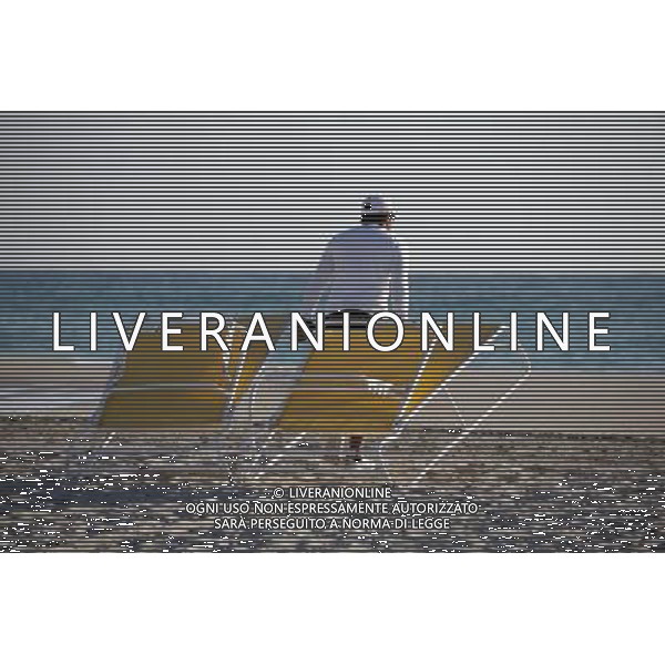 Man putting out deckchairs and sunloungers on the beach at South Beach on Miami Beach, America /Agenzia Aldo Liverani Sas - ITALY ONLY -