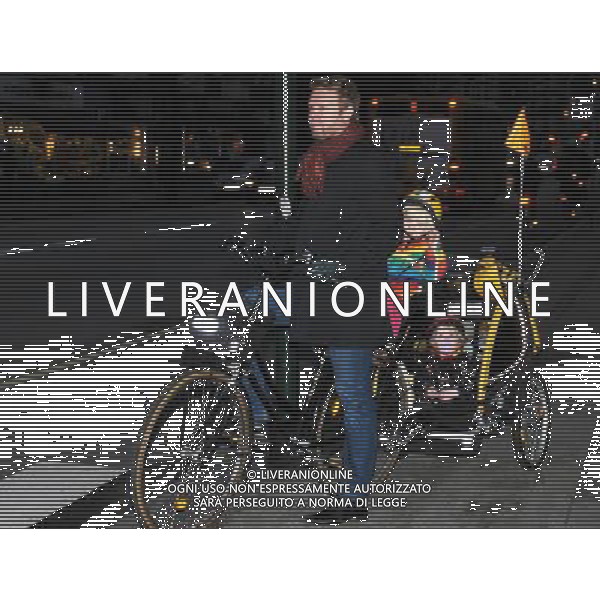 (091202) -- COPENHAGEN, Dec. 2, 2009 -- A bicycler taking his children waits to cross a street in Copenhagen, capital of Denmark, on Nov. 23, 2009. Copenhagen is known as one of the most bicycle-friendly cities in the world. 36% of all citizens commute to work or school by bicycle. Also, the city\'s bicycle paths are extensive and well used. The local government has also taken some measures to promote the energy-efficient, economical and enjoyable means of transportation. Zhao Changchun) (wjd) Ciclisti - persone in bicicletta - biciclette nella citta\' di Copenhagen capitale della Danimarca /Agenzia Aldo Liverani Sas - ITALY ONLY -