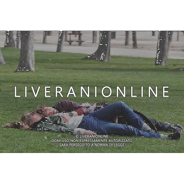 Spanish couple sleeping on the green grase of Retiro Park (Parque del Retiro) is a huge urban park located in Madrid Spain. The park features formal gardens, natural forests, a lake, a \'crystal\' palace and many beautiful sculptures and statues. Visitors to Madrid should most definitely allocate sufficient time to enjoy the many attractions located in the Retiro district of Madrid. USA OUT! ©Photoshot/Agenzia Aldo Liverani Sas - ITALY ONLY - VEDUTE DELLA CITTA\' DI MADRID - SPAGNA