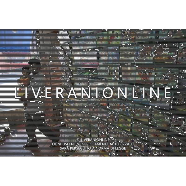 (100813) -- SINGAPORE, Aug. 13, 2010 () -- An Indian man walks by an indian music store with his child in Little India district, Singapore, Aug. 12, 2010. Little India, as the name promises, is the center for the large Indian community in Singapore. Indian temples, colorful sarees, jasmine garlands, as well as the smells of spice and blasts of Bollywood music make this district a distinct place to visit in Singapore. (/Cai Yang) (msq) ©photoshot/Agenzia Aldo Liverani Sas - ITALY ONLY - Il quartiere di Little India a Singapore, Little India, e\' il centro per la numerosa comunita\' indiana, templi indiani, saree colorati, ghirlande di gelsomini, cosi\' come gli odori di spezie e raffiche di musica di Bollywood fanno di questo quartiere un luogo da visitare