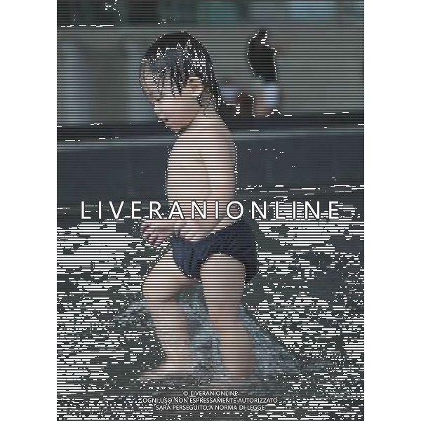 (100823) -- SINGAPORE, Aug. 23, 2010 -- A kid plays in a water pond in Singapore, Aug. 22, 2010. Temperature reached 32 degrees centigrade on Monday. Cai Yang) (zx) ©photoshot/Agenzia Aldo Liverani Sas - ITALY ONLY - Caldo, alte temperature, Bambino, bambini giocano con l\'acqua di una fontana di Singapore dove la temperatura ha superato i 30 gradi centigradi