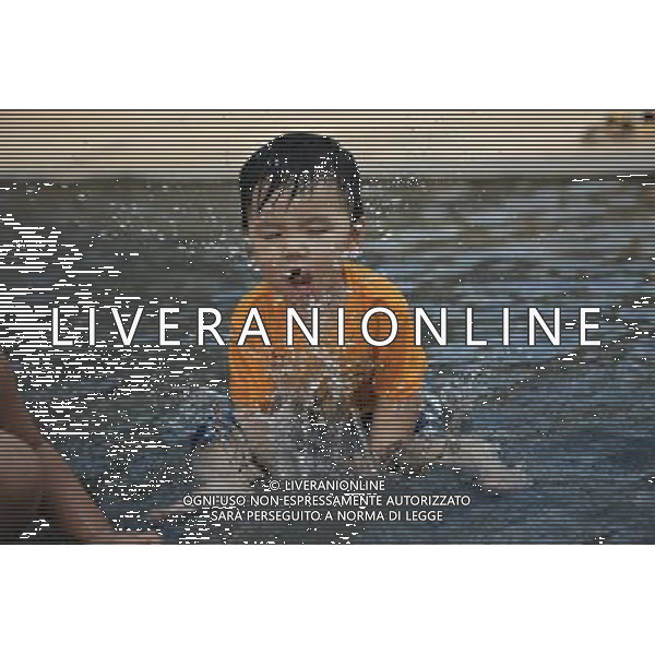 (100823) -- SINGAPORE, Aug. 23, 2010 -- A kid plays in a water pond in Singapore, Aug. 22, 2010. Temperature reached 32 degrees centigrade on Monday. Cai Yang) (zx) ©photoshot/Agenzia Aldo Liverani Sas - ITALY ONLY - Caldo, alte temperature, Bambino, bambini giocano con l\'acqua di una fontana di Singapore dove la temperatura ha superato i 30 gradi centigradi
