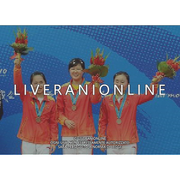 (101115) -- GUANGZHOU, Nov. 15, 2010 () -- China\'s Wang Chengyi (L), Hou Xiaoyu (C) and Huang Na pose for photos on the podium during the awarding ceremony of women\'s 50m Rifle Prone Team at the 16th Asian Games held in Guangzhou, capital of south China\'s Guangdong Province, Nov. 15, 2010. China won the bronze medal of the event. (/Song Zhenping) ©photoshot/Agenzia Aldo Liverani Sas - ITALY ONLY - 16a Giochi Asiatici di Guangzhou, nel sud della Cina