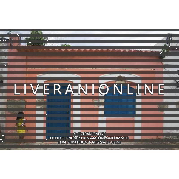 A young girl eating crisps walks past a pink-coloured colonial house in the southern Brazilian town of Morretes in the state of Paranà © Ed Stocker - Photoshot - Ag. Aldo Liverani sas ITALY ONLY VIAGGIO - VIAGGIARE - REPORTAGE BRASILE