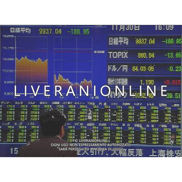 (101130) -- TOKYO, Nov. 30, 2010 () -- A man looks at a screen board showing graphs of Japan\'s stock price indexes in Tokyo, capital of Japan, on Nov. 30, 2010. The benchmark Nikkei index of the Tokyo Stock Exchange dropped by 1.87% on Tuesday. (/Ji Chunpeng) (zl) AG. ALDO LIVERANI SAS ITALY ONLY