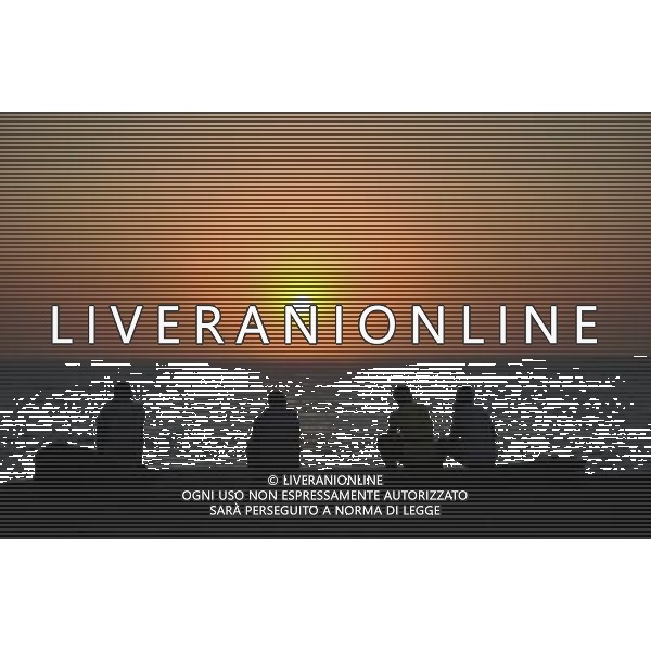 La gente guarda il tramonto su una spiaggia di Dakar, capitale del Senegal, 1 dicembre 2010. Dakar  situato sulla penisola di Cap-Vert, sulla costa atlantica del paese e sul bordo occidentale dell\'Africa. (/ Haitao Ding) (WJD) Photoshot-AGALDOLIVERANI ONLYITALY