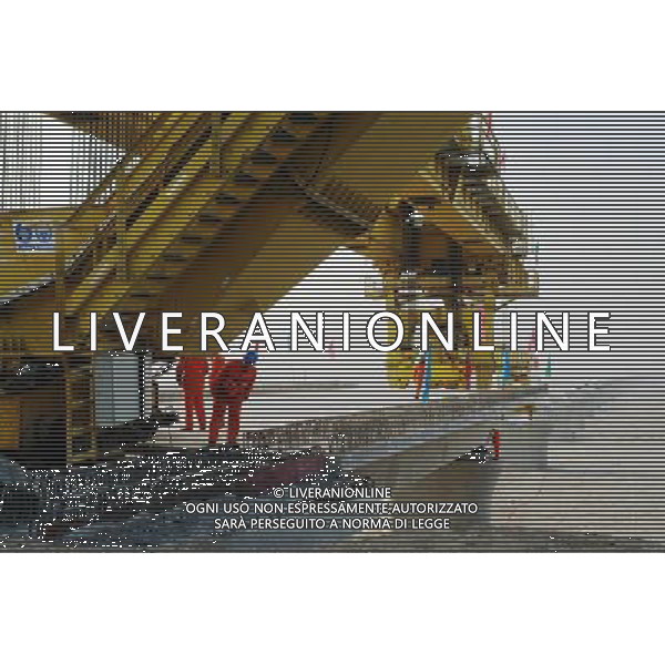 (101201) -- TURPAN, Dec. 1, 2010 () -- Wokers lay the first box girder onto bridge pillars of the Lanzhou-Xinjiang Railway crossing the wind field, which is dubbed as \'ghost\' for that windstorms of above 100 km per hour often running through it which once overthrown a train in 2007, in Turpan, northwest China\'s Xinjiang Uygur Autonomous Region, Nov. 30, 2010. Workers began laying 900-ton box girders on Tuesday onto those pillars with a total length of 7.795 km in the \'ghost\' wind field. The box girder laying operation will be finished by next April. (/Jiang Xiaoming) (zn) AG. ALDO LIVERANI SAS ITALY ONLY