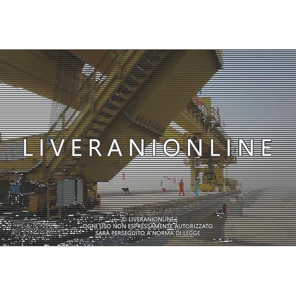 (101201) -- TURPAN, Dec. 1, 2010 () -- Wokers lay the first box girder onto bridge pillars of the Lanzhou-Xinjiang Railway crossing the wind field, which is dubbed as \'ghost\' for that windstorms of above 100 km per hour often running through it which once overthrown a train in 2007, in Turpan, northwest China\'s Xinjiang Uygur Autonomous Region, Nov. 30, 2010. Workers began laying 900-ton box girders on Tuesday onto those pillars with a total length of 7.795 km in the \'ghost\' wind field. The box girder laying operation will be finished by next April. (/Jiang Xiaoming) (zn) AG. ALDO LIVERANI SAS ITALY ONLY