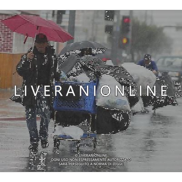 (101221) -- LOS ANGELES, Dec. 21, 2010 () -- A garbage collector walks across the street during a rain storm in Los Angeles, the United States, Dec. 20, 2010. Heavy rain in southern California already killed two people, forced hundreds of others to leave their homes and triggered the electricity cutoff in hundreds of thousands of houses during the last few days. (/Zhao Hanrong) (zf) AG. ALDO LIVERANI SAS ITALY ONLY