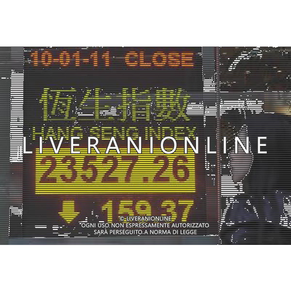 (110110) -- HONG KONG, Jan. 10, 2011 () -- A pedestrian walks pass the panel showing the Hang Seng Index in Hong Kong, south China, Jan. 10, 2011. Hong Kong stocks went down 159.37 points, or 0.67 percent, to close at 23,527.26 on Monday. (/Wong Pun Keung) (xzj) BORSA DI HONG KONG TABELLONI INDICANTI L\'INDICE HANG SENG AG. ALDO LIVERANI SAS ITALY ONLY