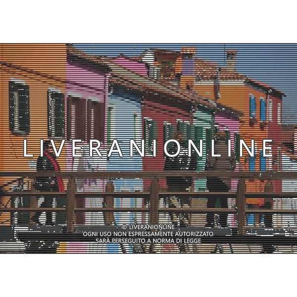 (110309) -- VENICE, March 9, 2011 () -- Tourists walk on a bridge to view the brightly-painted houses at Burano, an outlying island northeast of Venice, Italy, March 8, 2011. Villagers of the island have a long tradition to paint their houses colorfully, which today have become the main feature of the island. (/Wang Qingqin) (wjd) Vista della citta\' AG. ALDO LIVERANI SAS ITALY ONLY *** Local Caption *** .