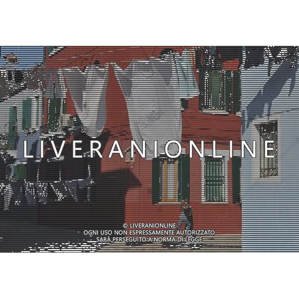 (110309) -- VENICE, March 9, 2011 () -- A girl runs along an alley between brightly-painted houses at Burano, an outlying island northeast of Venice, Italy, March 8, 2011. Villagers of the island have a long tradition to paint their houses colorfully, which today have become the main feature of the island. (/Wang Qingqin) (wjd) Vista della citta\' AG. ALDO LIVERANI SAS ITALY ONLY *** Local Caption *** .
