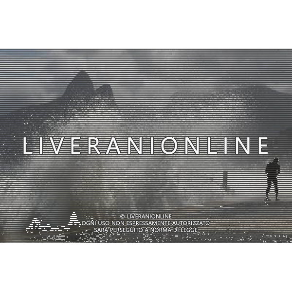 (110317) -- RIO DE JANEIRO, March 17, 2011 () -- A man walks near waves at Arpoador Beach, in Rio de Janeiro, Brazil, on March 16, 2011. Strong winds and an extratropical cyclone created rough seas off the southeast coast of Brazil. (/Agencia Estado)(BRAZIL OUT) (ce) AG. ALDO LIVERANI SAS ITALY ONLY *** Local Caption *** .