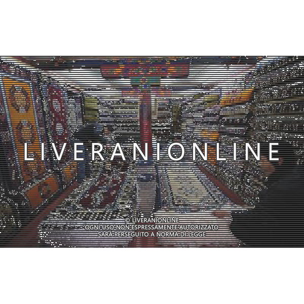 (110414) LHASA, April 14, 2011 () Customers pick Tibetan carpet in a shop on the Parkhor Street, in Lhasa, capital of southwest China\'s Tibet Autonomous Region, April 7, 2011. As one of the most distinct and attractive old blocks in the world, Parkhor Street is unique with contrastive features and stunning diversity. It is a place where Tibetan tradition meets modern fashion, religious sanctity mixes with commercial prosperity. Located in the center of Lhasa, surrounding the Jokhang Temple, it covers an area of 133.82 hectares and has 35 small streets and alleys extending in all directions. The Tibetan word Parkhor literally means \'an annular worshipping road\', which refers to the main street of the block. The main street, about two kilometers long, functions as the most important road for pilgrimage, local business, and tourism. In its 1400 years\' long history, Parkhor Street has witnessed the eclipse and prosperity of Buddhism, the exchange and fusion of the diverse cultures, the flourishing of ancient trade, the continuous changes of the regimes, and the ups and downs of Lhasa. Because of its unmatched location and cultural signification, Parkhor Street has long been considered as the epitome of Lhasa\'s historical development. It is the earliest and most prosperous business street in the city, crowded with merchants from all over China and even foreign countries such as Nepal and India, selling craftworks and products with rich ethnical features. Since the peaceful liberation of Tibet, the Parkhor Street has undergone fundamental changes. Common people moved into the former residence of noble families, handcraft workshops and stores appeared one after another, and shabby street infrastructure were thoroughly renovated. Along with China\'s Reform and Opening Up, the Parkhor Street in 1980\'s and 1990\'s saw a rise of commerce with increasing shops and abundant commodities. Tibetan artworks and craftworks gradually went popular in the market. Ther AG ALDO LIVERANI ONLY ITALY