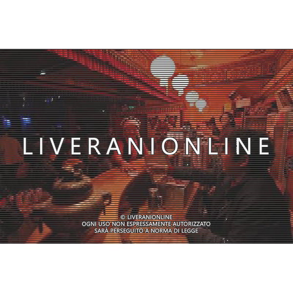 LHASA, May 9, 2011 Workers are busy selling beverage at a bar counter of Niwei Langma Hall in Lhasa, capital of southwest China\'s Tibet Autonomous Region, early May 7, 2011. It was 10:30 p.m. in Lhasa. Although most of the shops and restaurants were about to close, Niwei Langma hall was just warming up. Colorful spotlights illuminated the huge backdrop painting of the Potala Palace on the stage, while delightful Tibetan melody echoed around the hall. Guests were arriving in pairs or groups and quickly filled up the entertainment place. Dainzhencao, a newcome dancer, was busy dressing herself for the opening performance. She couldn\'t stop feeling nervous until she made sure her make up, costumes and decorations were all done, as she just danced this piece for a few times. However, at another dressing room, the experienced dancers were in an easy mood, as some were playing cell phone games, gossiping, and even knitting. The word \'Langma\' in Tibetan language means courtly performance, which in the past was only an entertainment for Tibetan traditional aristocracy. However, the present langma hall eventually evolved into a place of part bar, part folk concert hall and part ballroom, where common Tibetan people go for relaxation and gathering. Since the first such place opened in the mid 1990s, Langma halls soon became quite popular all over Tibet and emerged one after another in a short time. Today, Niwei is one of the biggest Langma halls in Lhasa. Its owner Gyaebo, who used to be a famous tap dancer in Lhasa, runs four langma halls of his own. All of his langma halls perform traditional Tibetan songs and dances, but in order to cater to different taste of customers, two langma halls emphasize on modern, western dance and even disco, while the others focus on Tibetan \'guozhuang\' and tap dance. There are more than 50 actors in Niwei Langma Hall, more than half of whom are at their 20\'s. They usually work for 5 6 hours per day, and attend two hour Scene di vita a Lhasa AG. ALDO LIVERANI SAS ITALY ONLY *** Local Caption *** .