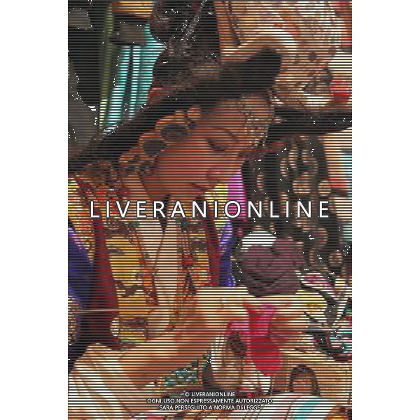 LHASA, May 9, 2011 Degyi Yangzom knits sweater before the show at the Niwei Langma Hall in Lhasa, capital of southwest China\'s Tibet Autonomous Region, May 5, 2011. It was 10:30 p.m. in Lhasa. Although most of the shops and restaurants were about to close, Niwei Langma hall was just warming up. Colorful spotlights illuminated the huge backdrop painting of the Potala Palace on the stage, while delightful Tibetan melody echoed around the hall. Guests were arriving in pairs or groups and quickly filled up the entertainment place. Dainzhencao, a newcome dancer, was busy dressing herself for the opening performance. She couldn\'t stop feeling nervous until she made sure her make up, costumes and decorations were all done, as she just danced this piece for a few times. However, at another dressing room, the experienced dancers were in an easy mood, as some were playing cell phone games, gossiping, and even knitting. The word \'Langma\' in Tibetan language means courtly performance, which in the past was only an entertainment for Tibetan traditional aristocracy. However, the present langma hall eventually evolved into a place of part bar, part folk concert hall and part ballroom, where common Tibetan people go for relaxation and gathering. Since the first such place opened in the mid 1990s, Langma halls soon became quite popular all over Tibet and emerged one after another in a short time. Today, Niwei is one of the biggest Langma halls in Lhasa. Its owner Gyaebo, who used to be a famous tap dancer in Lhasa, runs four langma halls of his own. All of his langma halls perform traditional Tibetan songs and dances, but in order to cater to different taste of customers, two langma halls emphasize on modern, western dance and even disco, while the others focus on Tibetan \'guozhuang\' and tap dance. There are more than 50 actors in Niwei Langma Hall, more than half of whom are at their 20\'s. They usually work for 5 6 hours per day, and attend two hour long rehe Scene di vita a Lhasa AG. ALDO LIVERANI SAS ITALY ONLY *** Local Caption *** .