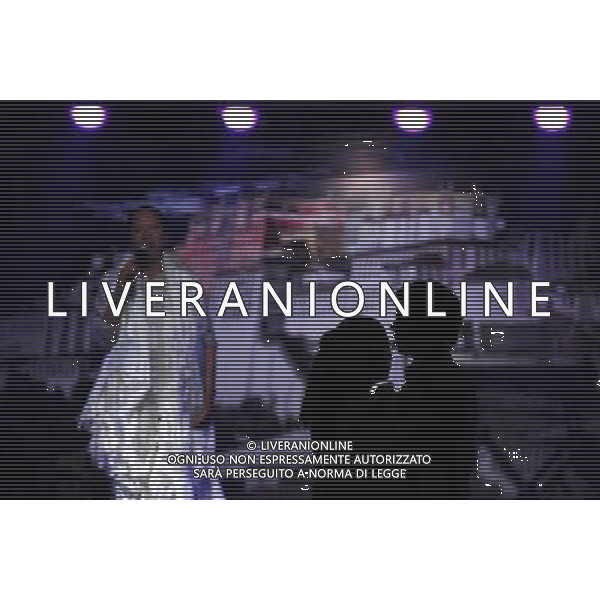 LHASA, May 9, 2011 Two guests have ballroom dance at New Century Langma Hall in Lhasa, capital of southwest China\'s Tibet Autonomous Region, early May 8, 2011. It was 10:30 p.m. in Lhasa. Although most of the shops and restaurants were about to close, Niwei Langma hall was just warming up. Colorful spotlights illuminated the huge backdrop painting of the Potala Palace on the stage, while delightful Tibetan melody echoed around the hall. Guests were arriving in pairs or groups and quickly filled up the entertainment place. Dainzhencao, a newcome dancer, was busy dressing herself for the opening performance. She couldn\'t stop feeling nervous until she made sure her make up, costumes and decorations were all done, as she just danced this piece for a few times. However, at another dressing room, the experienced dancers were in an easy mood, as some were playing cell phone games, gossiping, and even knitting. The word \'Langma\' in Tibetan language means courtly performance, which in the past was only an entertainment for Tibetan traditional aristocracy. However, the present langma hall eventually evolved into a place of part bar, part folk concert hall and part ballroom, where common Tibetan people go for relaxation and gathering. Since the first such place opened in the mid 1990s, Langma halls soon became quite popular all over Tibet and emerged one after another in a short time. Today, Niwei is one of the biggest Langma halls in Lhasa. Its owner Gyaebo, who used to be a famous tap dancer in Lhasa, runs four langma halls of his own. All of his langma halls perform traditional Tibetan songs and dances, but in order to cater to different taste of customers, two langma halls emphasize on modern, western dance and even disco, while the others focus on Tibetan \'guozhuang\' and tap dance. There are more than 50 actors in Niwei Langma Hall, more than half of whom are at their 20\'s. They usually work for 5 6 hours per day, and attend two hour long rehearsal Scene di vita a Lhasa AG. ALDO LIVERANI SAS ITALY ONLY *** Local Caption *** .