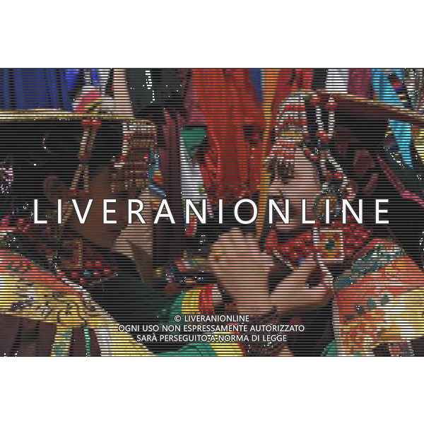 LHASA, May 9, 2011 Dancer Dainzhencao (L) trims dress for her friend Lhamo at the Niwei Langma Hall in Lhasa, capital of southwest China\'s Tibet Autonomous Region, May 5, 2011. It was 10:30 p.m. in Lhasa. Although most of the shops and restaurants were about to close, Niwei Langma hall was just warming up. Colorful spotlights illuminated the huge backdrop painting of the Potala Palace on the stage, while delightful Tibetan melody echoed around the hall. Guests were arriving in pairs or groups and quickly filled up the entertainment place. Dainzhencao, a newcome dancer, was busy dressing herself for the opening performance. She couldn\'t stop feeling nervous until she made sure her make up, costumes and decorations were all done, as she just danced this piece for a few times. However, at another dressing room, the experienced dancers were in an easy mood, as some were playing cell phone games, gossiping, and even knitting. The word \'Langma\' in Tibetan language means courtly performance, which in the past was only an entertainment for Tibetan traditional aristocracy. However, the present langma hall eventually evolved into a place of part bar, part folk concert hall and part ballroom, where common Tibetan people go for relaxation and gathering. Since the first such place opened in the mid 1990s, Langma halls soon became quite popular all over Tibet and emerged one after another in a short time. Today, Niwei is one of the biggest Langma halls in Lhasa. Its owner Gyaebo, who used to be a famous tap dancer in Lhasa, runs four langma halls of his own. All of his langma halls perform traditional Tibetan songs and dances, but in order to cater to different taste of customers, two langma halls emphasize on modern, western dance and even disco, while the others focus on Tibetan \'guozhuang\' and tap dance. There are more than 50 actors in Niwei Langma Hall, more than half of whom are at their 20\'s. They usually work for 5 6 hours per day, and attend two ho Scene di vita a Lhasa AG. ALDO LIVERANI SAS ITALY ONLY *** Local Caption *** .