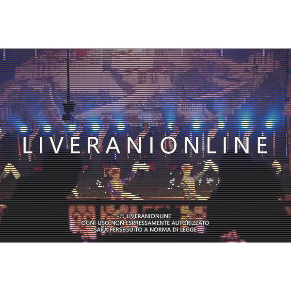 LHASA, May 9, 2011 Audiences watch a courtly dance at the Niwei Langma Hall in Lhasa, capital of southwest China\'s Tibet Autonomous Region, early May 5, 2011. It was 10:30 p.m. in Lhasa. Although most of the shops and restaurants were about to close, Niwei Langma hall was just warming up. Colorful spotlights illuminated the huge backdrop painting of the Potala Palace on the stage, while delightful Tibetan melody echoed around the hall. Guests were arriving in pairs or groups and quickly filled up the entertainment place. Dainzhencao, a newcome dancer, was busy dressing herself for the opening performance. She couldn\'t stop feeling nervous until she made sure her make up, costumes and decorations were all done, as she just danced this piece for a few times. However, at another dressing room, the experienced dancers were in an easy mood, as some were playing cell phone games, gossiping, and even knitting. The word \'Langma\' in Tibetan language means courtly performance, which in the past was only an entertainment for Tibetan traditional aristocracy. However, the present langma hall eventually evolved into a place of part bar, part folk concert hall and part ballroom, where common Tibetan people go for relaxation and gathering. Since the first such place opened in the mid 1990s, Langma halls soon became quite popular all over Tibet and emerged one after another in a short time. Today, Niwei is one of the biggest Langma halls in Lhasa. Its owner Gyaebo, who used to be a famous tap dancer in Lhasa, runs four langma halls of his own. All of his langma halls perform traditional Tibetan songs and dances, but in order to cater to different taste of customers, two langma halls emphasize on modern, western dance and even disco, while the others focus on Tibetan \'guozhuang\' and tap dance. There are more than 50 actors in Niwei Langma Hall, more than half of whom are at their 20\'s. They usually work for 5 6 hours per day, and attend two hour long rehearsals Scene di vita a Lhasa AG. ALDO LIVERANI SAS ITALY ONLY *** Local Caption *** .