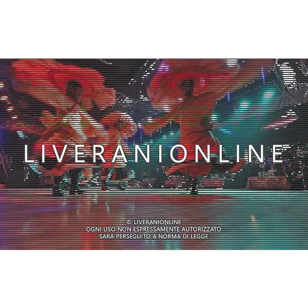 LHASA, May 9, 2011 Actors perform folk dance at the Snowland Gyaebo Langma Hall in Lhasa, capital of southwest China\'s Tibet Autonomous Region, May 6, 2011. It was 10:30 p.m. in Lhasa. Although most of the shops and restaurants were about to close, Niwei Langma hall was just warming up. Colorful spotlights illuminated the huge backdrop painting of the Potala Palace on the stage, while delightful Tibetan melody echoed around the hall. Guests were arriving in pairs or groups and quickly filled up the entertainment place. Dainzhencao, a newcome dancer, was busy dressing herself for the opening performance. She couldn\'t stop feeling nervous until she made sure her make up, costumes and decorations were all done, as she just danced this piece for a few times. However, at another dressing room, the experienced dancers were in an easy mood, as some were playing cell phone games, gossiping, and even knitting. The word \'Langma\' in Tibetan language means courtly performance, which in the past was only an entertainment for Tibetan traditional aristocracy. However, the present langma hall eventually evolved into a place of part bar, part folk concert hall and part ballroom, where common Tibetan people go for relaxation and gathering. Since the first such place opened in the mid 1990s, Langma halls soon became quite popular all over Tibet and emerged one after another in a short time. Today, Niwei is one of the biggest Langma halls in Lhasa. Its owner Gyaebo, who used to be a famous tap dancer in Lhasa, runs four langma halls of his own. All of his langma halls perform traditional Tibetan songs and dances, but in order to cater to different taste of customers, two langma halls emphasize on modern, western dance and even disco, while the others focus on Tibetan \'guozhuang\' and tap dance. There are more than 50 actors in Niwei Langma Hall, more than half of whom are at their 20\'s. They usually work for 5 6 hours per day, and attend two hour long rehearsals f Scene di vita a Lhasa AG. ALDO LIVERANI SAS ITALY ONLY *** Local Caption *** .