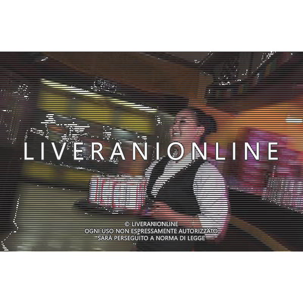 LHASA, May 9, 2011 A waitress serves beer at the New Century Langma Hall in Lhasa, capital of southwest China\'s Tibet Autonomous Region, early May 8, 2011. It was 10:30 p.m. in Lhasa. Although most of the shops and restaurants were about to close, Niwei Langma hall was just warming up. Colorful spotlights illuminated the huge backdrop painting of the Potala Palace on the stage, while delightful Tibetan melody echoed around the hall. Guests were arriving in pairs or groups and quickly filled up the entertainment place. Dainzhencao, a newcome dancer, was busy dressing herself for the opening performance. She couldn\'t stop feeling nervous until she made sure her make up, costumes and decorations were all done, as she just danced this piece for a few times. However, at another dressing room, the experienced dancers were in an easy mood, as some were playing cell phone games, gossiping, and even knitting. The word \'Langma\' in Tibetan language means courtly performance, which in the past was only an entertainment for Tibetan traditional aristocracy. However, the present langma hall eventually evolved into a place of part bar, part folk concert hall and part ballroom, where common Tibetan people go for relaxation and gathering. Since the first such place opened in the mid 1990s, Langma halls soon became quite popular all over Tibet and emerged one after another in a short time. Today, Niwei is one of the biggest Langma halls in Lhasa. Its owner Gyaebo, who used to be a famous tap dancer in Lhasa, runs four langma halls of his own. All of his langma halls perform traditional Tibetan songs and dances, but in order to cater to different taste of customers, two langma halls emphasize on modern, western dance and even disco, while the others focus on Tibetan \'guozhuang\' and tap dance. There are more than 50 actors in Niwei Langma Hall, more than half of whom are at their 20\'s. They usually work for 5 6 hours per day, and attend two hour long rehearsals fo Scene di vita a Lhasa AG. ALDO LIVERANI SAS ITALY ONLY *** Local Caption *** .