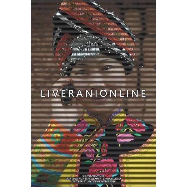 KUNMING, May 17, 2011 Photo taken on Jan 10, 2009 shows a Yi ethnic group woman, from Yao\'an county of Yi Autonomous Prefecture of Chuxiong, southwest China\'s Yunnan Province, calls her relatives with a mobile phone. The 43rd World Telecommunication Day falls on Tuesday with the theme of \'Information and Communication Technology makes rural life better\'. In recent years, telecommunication industries in Yunnan have developed rapidly, completing a modern communication network that covers urban and rural areas. (/Lin Yiguang) Immagini del popolo Tibetano con apparecchiature eletriche -Cellulari - Cpmputers AG. ALDO LIVERANI SAS ITALY ONLY *** Local Caption *** .