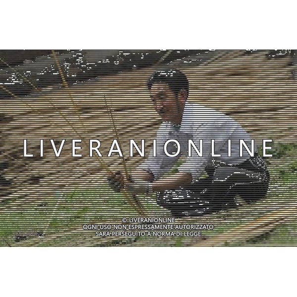 (110517) -- BEIJING, May 17, 2011 () -- Da Lin, a villager of Lhoba ethnic group, weaves basket with bamboo pieces in Qionglin Village of Nanyi Lhoba Ethnic Township, in Mainling County of southwest China\'s Tibet Autonomous Region (TAR), May 11, 2011. He is one of the few people who knows this traditional Lhoba handicraft. Located at the foot of snow-peaked mountains near the south border between China and India, the Nanyi Township of Qionglin Village, a tranquil and picturesque place, is inhabited by people of Lhoba ethnic group. With a total of 2900 people, Lhoba ethnic group is the smallest among China\'s 56 ethnic groups in term of population. The family of forty-six-year-old Ma Ya is one of the 30 Lhoba households in the village. They live in a two-storeyed house with many modern devices like television, washing machine, refrigerator, etc. In 2008, his family opened a household inn when Qionglin Village set up a scenic area. Their family inn soon went popular among tourists, and earned them about 6,000 yuan (922 U. S. dollars) per month at the tourism peak season from June to October. Yet just 50 years ago, before Ma Ya\'s birth, his father and grandfather still lived in the wood, depending mainly on hunting with bows and arrows, in the very form of a primitive society. As few knew their existence in the wildest nature, they were dubbed as \'the tribe of mystery\'. In the 1960s, after the peaceful liberation of Tibet, Ma Ya\'s father and some other Lhoba people moved out of the wood and settled on a land offered by the local government. By 1985, all the Lhoba people of the village have moved into free dwelling houses and started to breed livestock provided by the government, thus marking the brand-new start of their modern life. Instead of hunting and logging, their previous livelihood, local villagers of Lhoba now earn their living on stockbreeding, bamboo weaving, herbal medicine picking, and tourism. Under the benefits of many national policies pr Situato ai piedi delle montagne innevate, vicino al confine meridionale tra la Cina e l\'India, il Comune di Nanyi Qionglin Village, un luogo pittoresco e tranquillo, abitato da persone del gruppo etnico Lhoba. Con un totale di 2900 persone, il gruppo etnico Lhoba  il pi piccolo dei 56 gruppi etnici in termini di popolazione in Cina Etnie - Vita - Rurali - AG. ALDO LIVERANI SAS ITALY ONLY *** Local Caption *** .