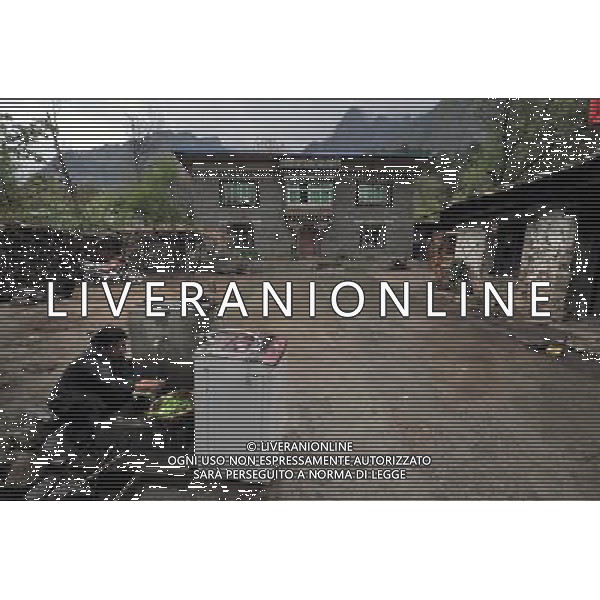 (110517) -- BEIJING, May 17, 2011 () -- Ya Niang, a villager of Lhoba ethnic group, washes vegetable in the yard of her house in Qionglin Village of Nanyi Lhoba Ethnic Township, in Mainling County of southwest China\'s Tibet Autonomous Region (TAR), May 12, 2011. Located at the foot of snow-peaked mountains near the south border between China and India, the Nanyi Township of Qionglin Village, a tranquil and picturesque place, is inhabited by people of Lhoba ethnic group. With a total of 2900 people, Lhoba ethnic group is the smallest among China\'s 56 ethnic groups in term of population. The family of forty-six-year-old Ma Ya is one of the 30 Lhoba households in the village. They live in a two-storeyed house with many modern devices like television, washing machine, refrigerator, etc. In 2008, his family opened a household inn when Qionglin Village set up a scenic area. Their family inn soon went popular among tourists, and earned them about 6,000 yuan (922 U. S. dollars) per month at the tourism peak season from June to October. Yet just 50 years ago, before Ma Ya\'s birth, his father and grandfather still lived in the wood, depending mainly on hunting with bows and arrows, in the very form of a primitive society. As few knew their existence in the wildest nature, they were dubbed as \'the tribe of mystery\'. In the 1960s, after the peaceful liberation of Tibet, Ma Ya\'s father and some other Lhoba people moved out of the wood and settled on a land offered by the local government. By 1985, all the Lhoba people of the village have moved into free dwelling houses and started to breed livestock provided by the government, thus marking the brand-new start of their modern life. Instead of hunting and logging, their previous livelihood, local villagers of Lhoba now earn their living on stockbreeding, bamboo weaving, herbal medicine picking, and tourism. Under the benefits of many national policies preferential for minority groups, the annual income per capita o Situato ai piedi delle montagne innevate, vicino al confine meridionale tra la Cina e l\'India, il Comune di Nanyi Qionglin Village, un luogo pittoresco e tranquillo, abitato da persone del gruppo etnico Lhoba. Con un totale di 2900 persone, il gruppo etnico Lhoba  il pi piccolo dei 56 gruppi etnici in termini di popolazione in Cina Etnie - Vita - Rurali - AG. ALDO LIVERANI SAS ITALY ONLY *** Local Caption *** .