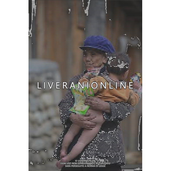 (110517) -- BEIJING, May 17, 2011 () -- Eighty-year-old Ya Niang holds her granddaughter in arms in Qionglin Village of Nanyi Lhoba Ethnic Township, in Mainling County of southwest China\'s Tibet Autonomous Region (TAR), May 11, 2011. Located at the foot of snow-peaked mountains near the south border between China and India, the Nanyi Township of Qionglin Village, a tranquil and picturesque place, is inhabited by people of Lhoba ethnic group. With a total of 2900 people, Lhoba ethnic group is the smallest among China\'s 56 ethnic groups in term of population. The family of forty-six-year-old Ma Ya is one of the 30 Lhoba households in the village. They live in a two-storeyed house with many modern devices like television, washing machine, refrigerator, etc. In 2008, his family opened a household inn when Qionglin Village set up a scenic area. Their family inn soon went popular among tourists, and earned them about 6,000 yuan (922 U. S. dollars) per month at the tourism peak season from June to October. Yet just 50 years ago, before Ma Ya\'s birth, his father and grandfather still lived in the wood, depending mainly on hunting with bows and arrows, in the very form of a primitive society. As few knew their existence in the wildest nature, they were dubbed as \'the tribe of mystery\'. In the 1960s, after the peaceful liberation of Tibet, Ma Ya\'s father and some other Lhoba people moved out of the wood and settled on a land offered by the local government. By 1985, all the Lhoba people of the village have moved into free dwelling houses and started to breed livestock provided by the government, thus marking the brand-new start of their modern life. Instead of hunting and logging, their previous livelihood, local villagers of Lhoba now earn their living on stockbreeding, bamboo weaving, herbal medicine picking, and tourism. Under the benefits of many national policies preferential for minority groups, the annual income per capita of Nanyi Township reached 5760 Situato ai piedi delle montagne innevate, vicino al confine meridionale tra la Cina e l\'India, il Comune di Nanyi Qionglin Village, un luogo pittoresco e tranquillo, abitato da persone del gruppo etnico Lhoba. Con un totale di 2900 persone, il gruppo etnico Lhoba  il pi piccolo dei 56 gruppi etnici in termini di popolazione in Cina Etnie - Vita - Rurali - AG. ALDO LIVERANI SAS ITALY ONLY *** Local Caption *** .