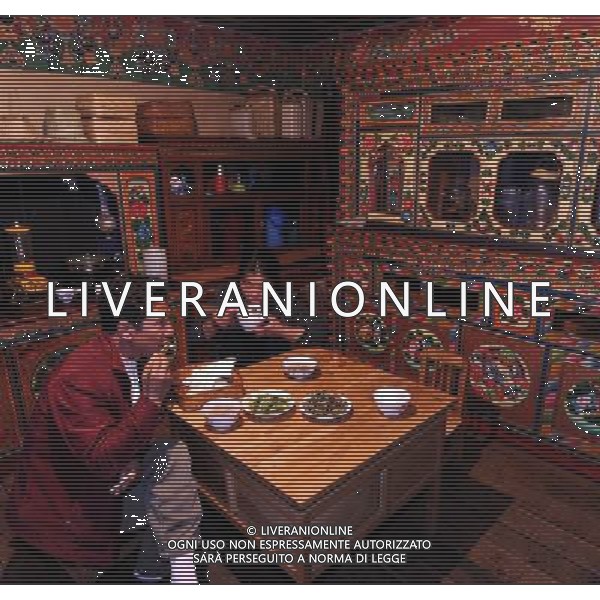 (110517) -- BEIJING, May 17, 2011 () -- Ya Niang (R) and Ma Ya, villagers of Lhoba ethnic group, have lunch at their home in Qionglin Village of Nanyi Lhoba Ethnic Township, in Mainling County of southwest China\'s Tibet Autonomous Region (TAR), May 11, 2011. Located at the foot of snow-peaked mountains near the south border between China and India, the Nanyi Township of Qionglin Village, a tranquil and picturesque place, is inhabited by people of Lhoba ethnic group. With a total of 2900 people, Lhoba ethnic group is the smallest among China\'s 56 ethnic groups in term of population. The family of forty-six-year-old Ma Ya is one of the 30 Lhoba households in the village. They live in a two-storeyed house with many modern devices like television, washing machine, refrigerator, etc. In 2008, his family opened a household inn when Qionglin Village set up a scenic area. Their family inn soon went popular among tourists, and earned them about 6,000 yuan (922 U. S. dollars) per month at the tourism peak season from June to October. Yet just 50 years ago, before Ma Ya\'s birth, his father and grandfather still lived in the wood, depending mainly on hunting with bows and arrows, in the very form of a primitive society. As few knew their existence in the wildest nature, they were dubbed as \'the tribe of mystery\'. In the 1960s, after the peaceful liberation of Tibet, Ma Ya\'s father and some other Lhoba people moved out of the wood and settled on a land offered by the local government. By 1985, all the Lhoba people of the village have moved into free dwelling houses and started to breed livestock provided by the government, thus marking the brand-new start of their modern life. Instead of hunting and logging, their previous livelihood, local villagers of Lhoba now earn their living on stockbreeding, bamboo weaving, herbal medicine picking, and tourism. Under the benefits of many national policies preferential for minority groups, the annual income per capita of Na Situato ai piedi delle montagne innevate, vicino al confine meridionale tra la Cina e l\'India, il Comune di Nanyi Qionglin Village, un luogo pittoresco e tranquillo, abitato da persone del gruppo etnico Lhoba. Con un totale di 2900 persone, il gruppo etnico Lhoba  il pi piccolo dei 56 gruppi etnici in termini di popolazione in Cina Etnie - Vita - Rurali - AG. ALDO LIVERANI SAS ITALY ONLY *** Local Caption *** .