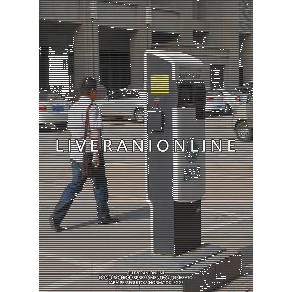 ZHENGZHOU, May 17, 2011 A resident passes by an AC charging pile for electric vehicles in a street in Zhengzhou, capital of central China\'s Henan Province, May 17, 2011. A total of 40 AC charging piles have been allocated in Zhengzhou City to facilitate the battery recharging of electric vehicles whose number is increasing in the city. (/Wang Song) (zn) Colonnine per la ricarica di auto elettriche in Cina AG.ALDO LIVERANI SAS ITALY ONLY *** Local Caption *** .