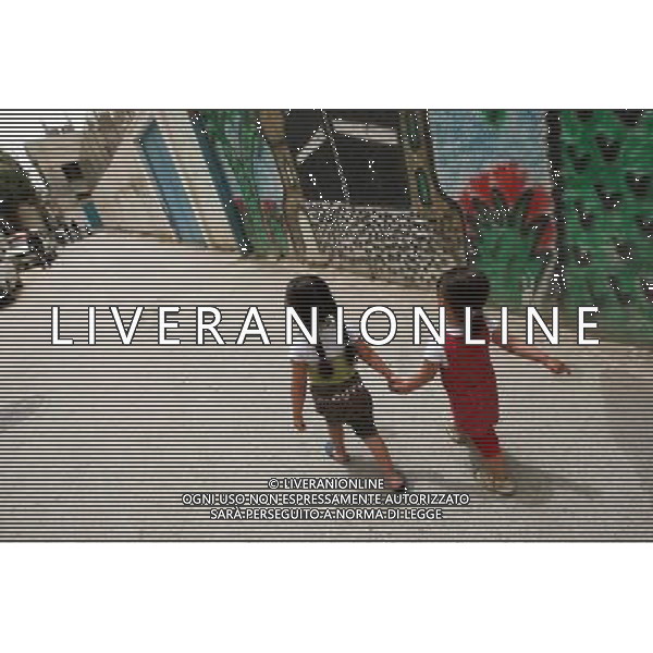 (110518) -- BETHLEHEM, May 18, 2011 () -- Two Palestinian girls walk hand in hand in a refugee camp in the West Bank city of Bethlehem, May 18, 2011. May 15, 1948 is the day of the creation of Israel, but of \'Nakba\' (catastrophe) for Palestinians who were displaced ever since and have lived in the West Bank, Gaza Strip, Jordan, Syria and Lebanon. Children who were born in the refugee camps suffer both physically and psychologically during their miserable childhood. (/Chen Xu) Bimbini in un campo profughi nella cittö cisgiordana di Betlemme AG. ALDO LIVERANI SAS ITALY ONLY *** Local Caption *** .