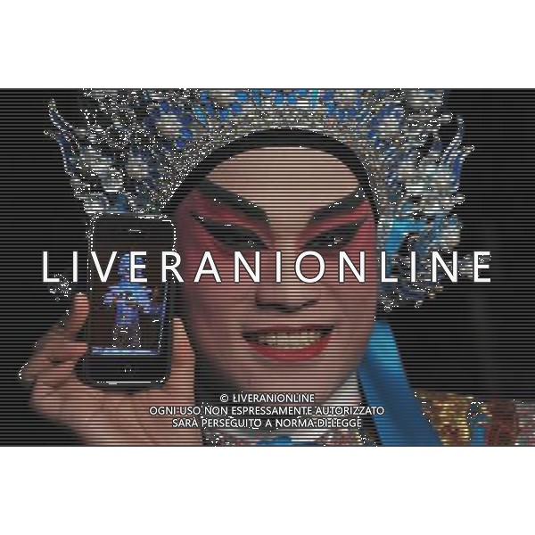 (110602) -- HONG KONG, June 2, 2011 () -- An opera player shows a photo of himself after make-up in south China\'s Hong Kong, June 2, 2011. Chinese Opera Festival will be held here from June 3 and nine opera troupes will perform traditional Chinese operas during the festival. (/Chen Xiaowei) (lfj) Cinese Opera Festival si svolgerš qui dal 3 giugno e nove compagnie d\'opera si esibiranno nelle tradizionali opere cinesi durante il festival AG. ALDO LIVERANI SAS ITALY ONLY *** Local Caption *** .