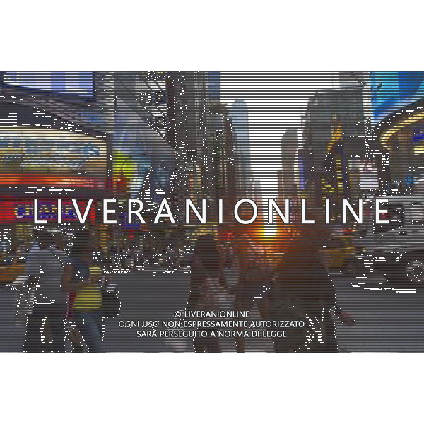 Visitors to Times Square in New York pass the Manhattanhenge sunset on Monday, May 30, 2011. Twice a year, this year on May 30 and July 12, the sun lines up at sunset with the city\'s grid, lighting up both sides of the street and setting in the middle of the roadways. The event, the name coined by Neil deGrasse Tyson of the Hayden Planetarium, takes place 22 days before and 21 days after the summer solstice because of the 30 degree angle of the city\'s grid, it is not exactly east-west-north-south. ©photoshot/Agenzia Aldo Liverani Sas - ITALY ONLY - Gli abitanti e Turisti a New York affollano la citta\' nell\'inizio non ufficiale dell\'estate