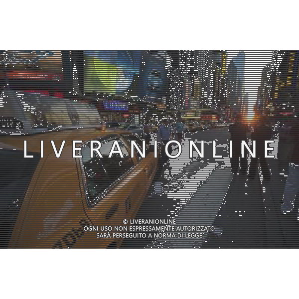 Visitors to Times Square in New York pass the Manhattanhenge sunset on Monday, May 30, 2011. Twice a year, this year on May 30 and July 12, the sun lines up at sunset with the city\'s grid, lighting up both sides of the street and setting in the middle of the roadways. The event, the name coined by Neil deGrasse Tyson of the Hayden Planetarium, takes place 22 days before and 21 days after the summer solstice because of the 30 degree angle of the city\'s grid, it is not exactly east-west-north-south. (å© Richard B. Levine ©photoshot/Agenzia Aldo Liverani Sas - ITALY ONLY - Gli abitanti e Turisti a New York affollano la citta\' nell\'inizio non ufficiale dell\'estate