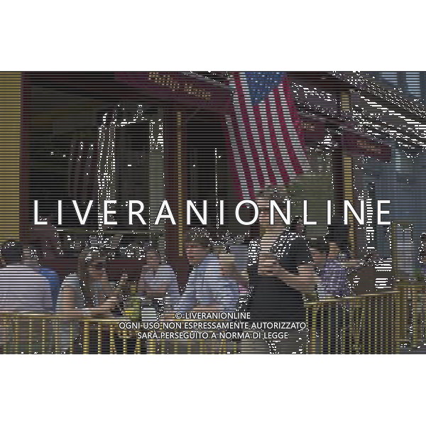 A woman carrying iced coffees passes people dining al fresco at the Philip Marie Restaurant in the Greenwich Village neighborhood in New York on Saturday, June 4, 2011. (å© Frances M. Roberts) /PHOTOSHOT/AG ALDO LIVERANI SAS - ITALY ONLY - *** Local Caption *** .