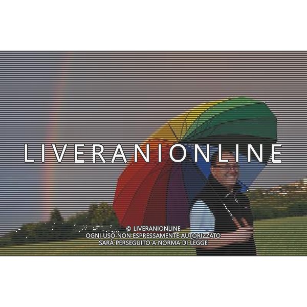 (110702) -- BOCHUM, July 2, 2011 -- A man walks with a rainbow-colord umbrella while a rainbow arches across the sky near Bochum, west Germany, July 1, 2011. Wu Wei) (lyx)