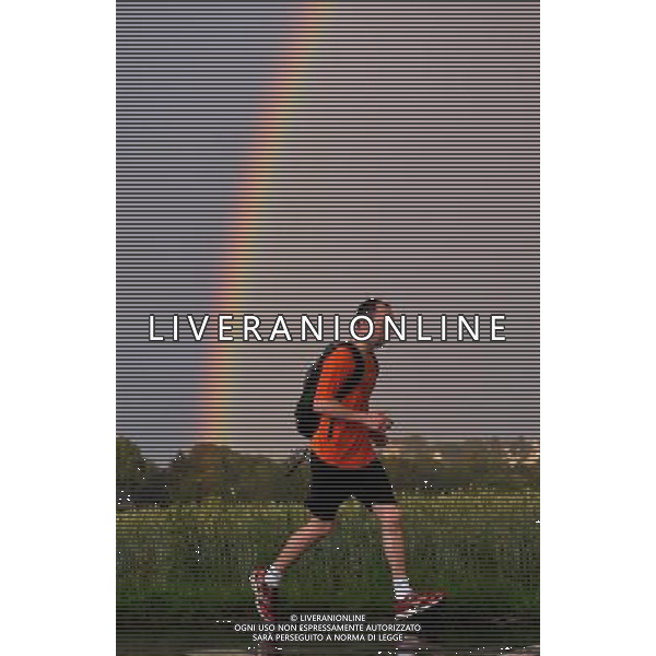 (110702) -- BOCHUM, July 2, 2011 -- A man runs in the rain while a rainbow arches across the sky near Bochum, west Germany, July 1, 2011. Wu Wei) (lyx)