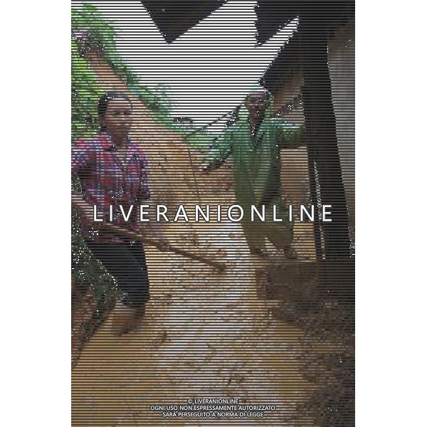 (110703) -- MENGLA, July 3, 2011 () -- Villagers clean up the landslide dirt at their backyard in Mengla County of Autonomous Prefecture of Xishuangbanna, southwest China\'s Yunnan Province, July 2, 2011. The lingering rainfalls here have caused several landslides and affected agricultural production. (/Li Yunsheng) (lfj)