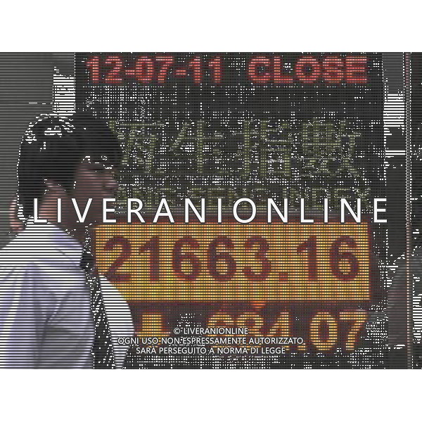 (110712) -- HONG KONG, July 12, 2011 () -- A pedestrian walks past a quotation panel showing Hang Seng Index in Hong Kong, south China, July 12, 2011. Hong Kong stocks tumbled 684.07 points, or 3.06 percent, to close at 21,663.16 on Tuesday, following sharp decreases overnight in the U.S. stock market. (/Wong Pun Keung)
