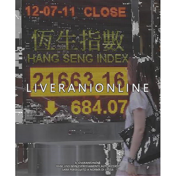 (110712) -- HONG KONG, July 12, 2011 () -- A pedestrian walks past a quotation panel showing Hang Seng Index in Hong Kong, south China, July 12, 2011. Hong Kong stocks tumbled 684.07 points, or 3.06 percent, to close at 21,663.16 on Tuesday, following sharp decreases overnight in the U.S. stock market. (/Wong Pun Keung)