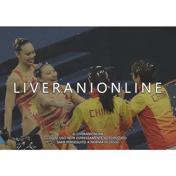 SHANGHAI, July 18, 2011 Huang Xuechen (1st L) and Liu Ou (2nd L) of China hug their coaches after the final of the technical duets of synchronized swimming event at the 14th FINA World Championships in Shanghai, east China, July 18, 2011. The Chinese duet grabbed the silver medal with 96.500 points. (/Yang Lei) (zgp)