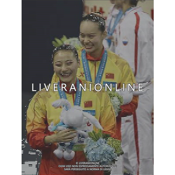SHANGHAI, July 18, 2011 Huang Xuechen and Liu Ou (front) of China attend the awarding ceremony of the technical duets of synchronized swimming event at the 14th FINA World Championships in Shanghai, east China, July 18, 2011. The Chinese duet grabbed the silver medal with 96.500 points. (/Ren Long) (zgp)