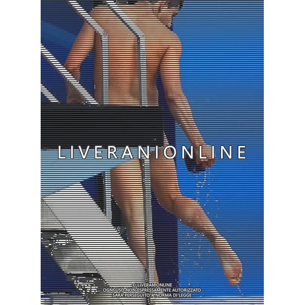 SHANGHAI, July 18, 2011 Daniel Islas of Mexico looks at his injured leg after his last dive in the final of the men\'s 1m springboard diving event at the 14th FINA World Championships in Shanghai, east China, July 18, 2011. Daniel Islas banged his right leg onto the board before he hit the water in his last dive and only finished the 11th with 307.35 points. (/Chen Fei) (zgp)