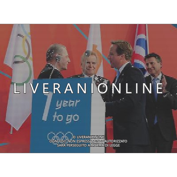 (110727) -- LONDON, July 27, 2011 () -- International Olympic Committee (IOC) President Jacques Rogge (L) and British Prime Minister David Cameron (2nd R) shake hands during the \'London 2012 - One Year To Go\' celebration at Trafalgar Square in central London, Britain, July 27, 2011. London celebrated the one year countdown to the London 2012 Olympic games here on Wednesday. (/Zeng Yi)