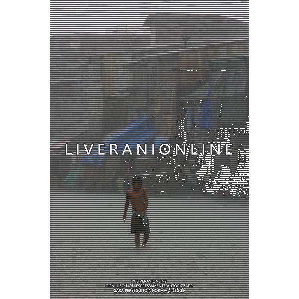 (110727) -- MANILA, July 27, 2011 () -- Children play in the rain as classes were suspended due to tropical storm Nock-ten in Manila, the Philippines, on July 27, 2011. The country\'s National Disaster Risk Reduction and Management Council said the death toll rose to at least 14 due to rains and floods brought by tropical storm Nock-Ten. (/Rouelle Umali) (jy)