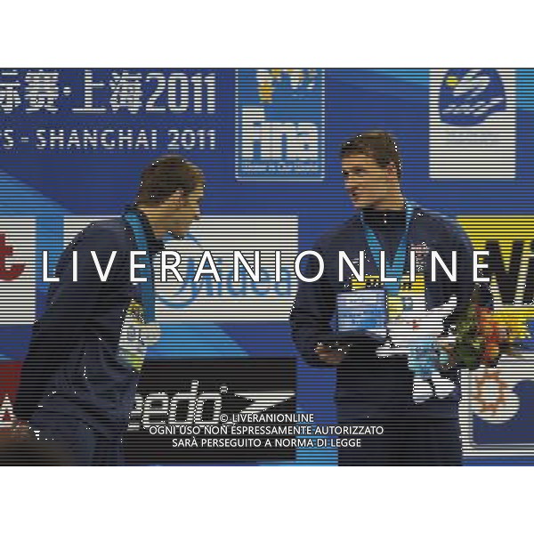 (110728) -- SHANGHAI, July 28, 2011 () -- Michael Phelps (L) of the United States checks out his teammate Ryan Lochte\'s certificate for setting a new world record in the awarding ceremony of men\'s 200m individual medley swimming event at the 14th FINA World Championships in Shanghai, east China, July 28, 2011. Ryan Lochte claimed the title and set a new world record with 1:54.00. Michael Phelps won the silver medal with 1:54.16. (/Yang Lei) (sqq)
