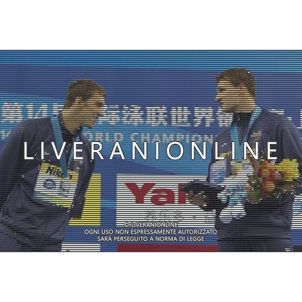 (110728) -- SHANGHAI, July 28, 2011 () -- Michael Phelps (L) of the United States checks out his teammate Ryan Lochte\'s certificate for setting a new world record in the awarding ceremony of men\'s 200m individual medley swimming event at the 14th FINA World Championships in Shanghai, east China, July 28, 2011. Ryan Lochte claimed the title and set a new world record with 1:54.00. Michael Phelps won the silver medal with 1:54.16. (/Fan Jun) (sqq)